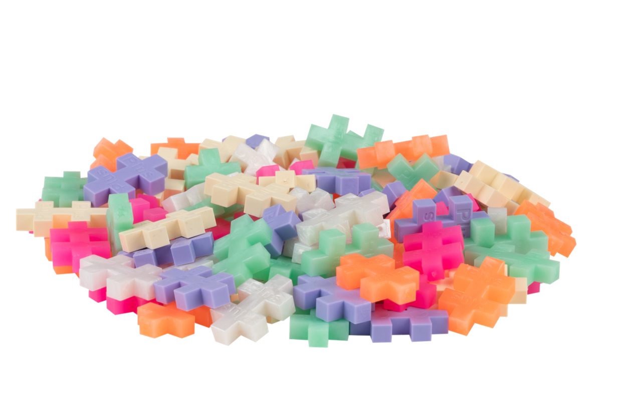 Perłowe klocki PLUS-PLUS wysypane z tuby, prezentujące pastelowe kolory i charakterystyczny kształt elementów