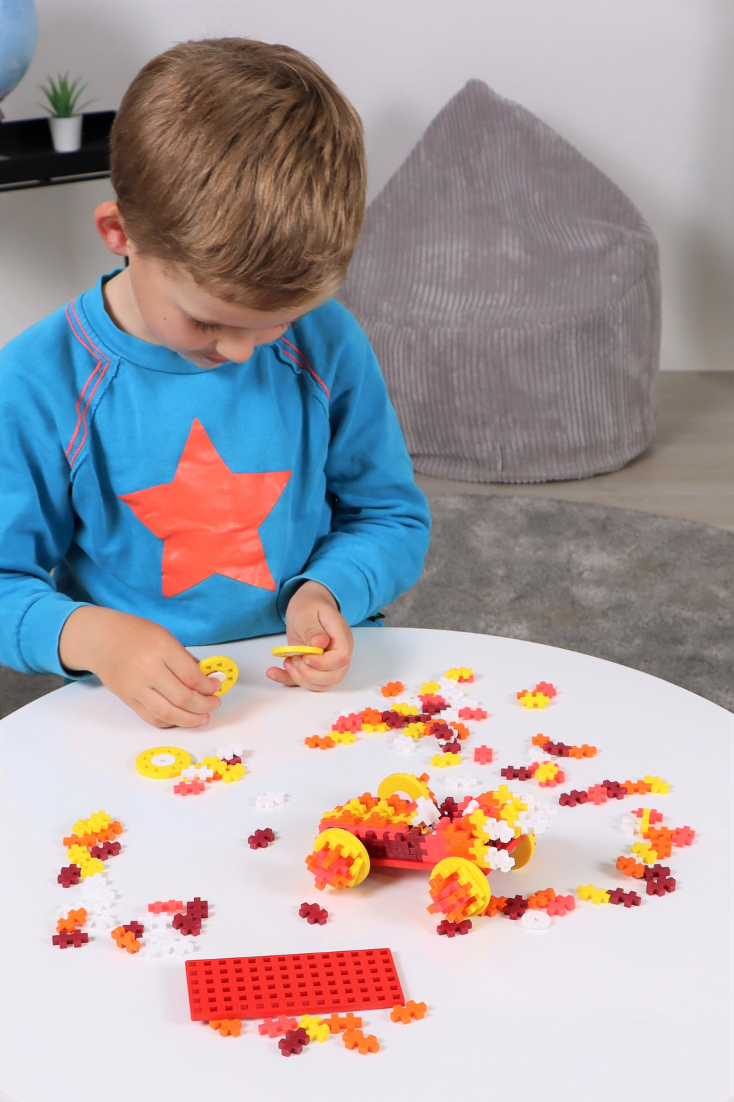 Zawartość zestawu Plus-Plus Auto 200 elementów wysypana z opakowania – klocki, koła i baza