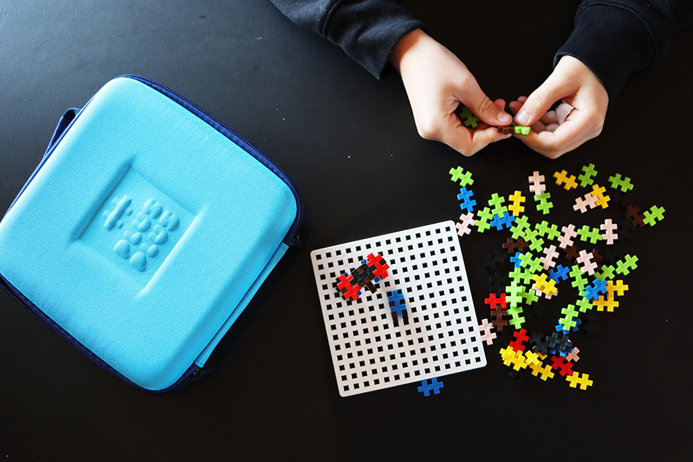 Klocki Plus-Plus na podstawce i w walizce podróżnej